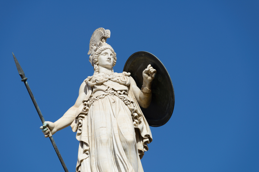 A marble statue of Athena against a blue sky