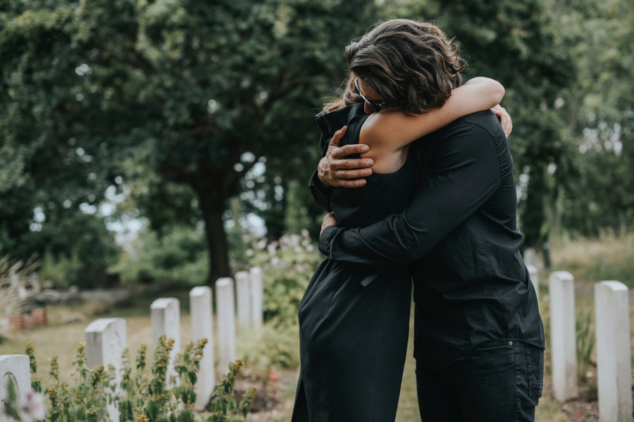 Two people embracing in a hug in an attempt to recover from grief and loss