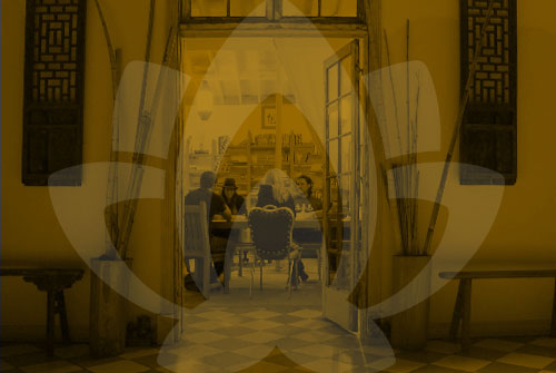 a group of people sitting at a table, framed by a large door, during a trauma focused therapy group in orange county, ca