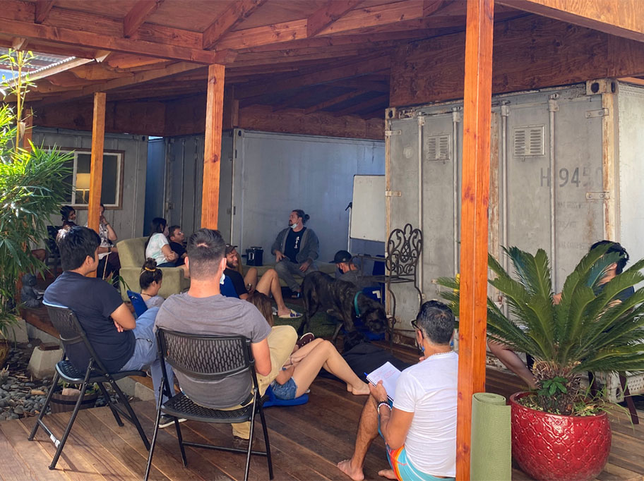 A dozen people take part in a seminar while sitting on the wood patio of our anxiety treatment center during the daytime