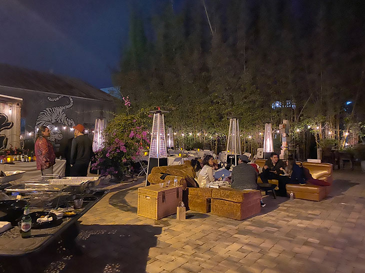 Our depression treatment center's courtyard at night. Four people chat on a couch. Three others chat standing up.