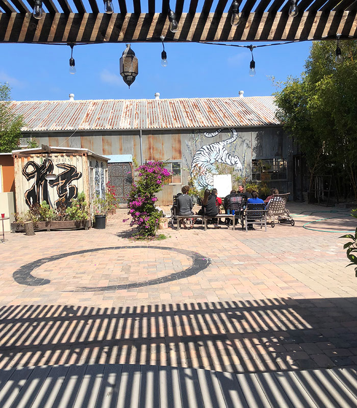 Our depression treatment center courtyard with a dark circle painted on the ground. Eight people sit at a picnic table.