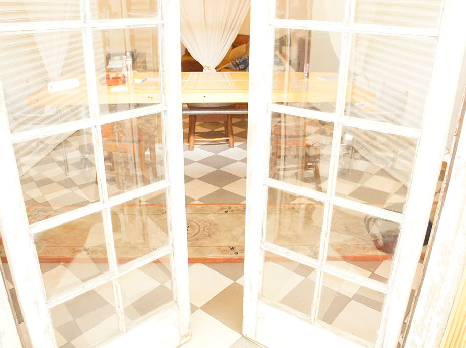 A view through the partially cracked doorway of our OCD treatment facility. A wooden table and chairs sit in the room.