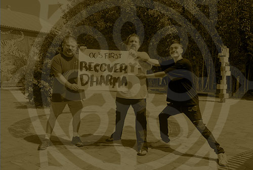 three men holding a poster board that says “recovery dharma” for a free recovery support group in orange county, CA