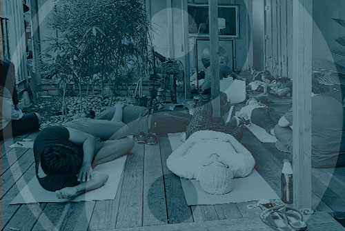 a group of people laying on a wooden floor during a qi gong class in california