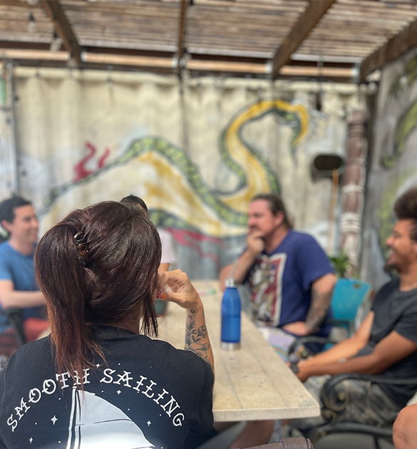two men sitting and laughing as one receives mental health services in CA